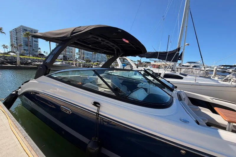 Slide: The Image of 2024 Sea Ray SLX 260 boat docked at marina under clear blue sky. - 8