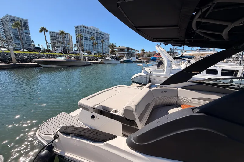 Slide: The Image of 2024 Sea Ray SLX 260 luxury boat docked in a marina with modern buildings. - 9