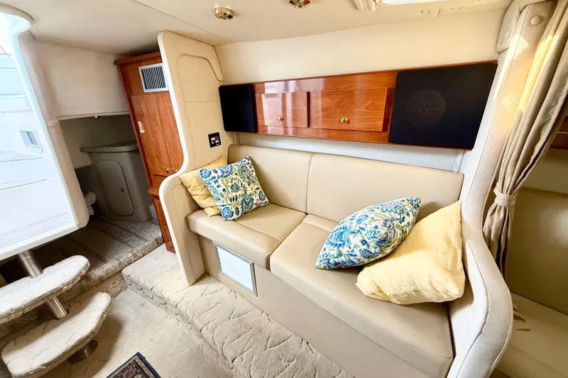Slide: The Image of 2005 Rinker Fiesta Vee 300 interior with beige seating and decorative pillows. - 16