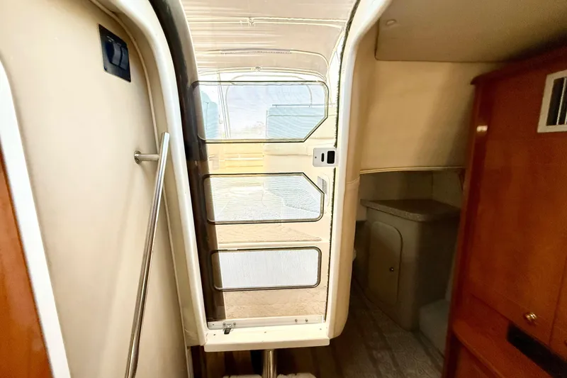 Slide: The Image of Interior view of 2005 Rinker Fiesta Vee 300 cabin with door and wooden cabinetry. - 24