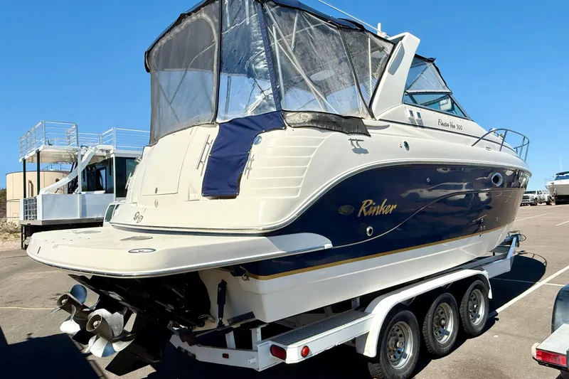 Slide: The Image of 2005 Rinker Fiesta Vee 300 boat on trailer, featuring sleek design and blue accents. - 3