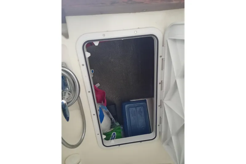 Slide: The Image of Storage compartment on a 1978 Pearson 424 sailboat, containing various items. - 11