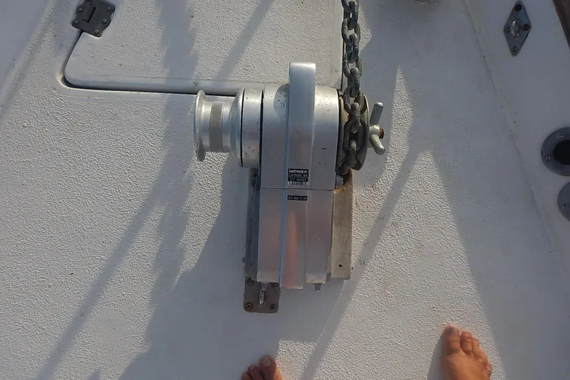 Slide: The Image of Anchor windlass on 1978 Pearson 424 sailboat deck with chain and manual handle. - 12