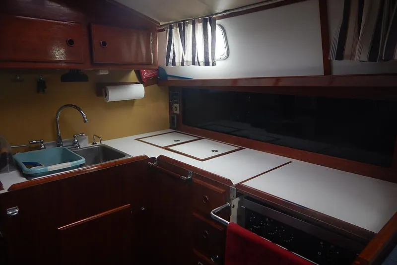 Slide: The Image of 1978 Pearson 424 yacht interior kitchen with wooden cabinets and modern amenities. - 20