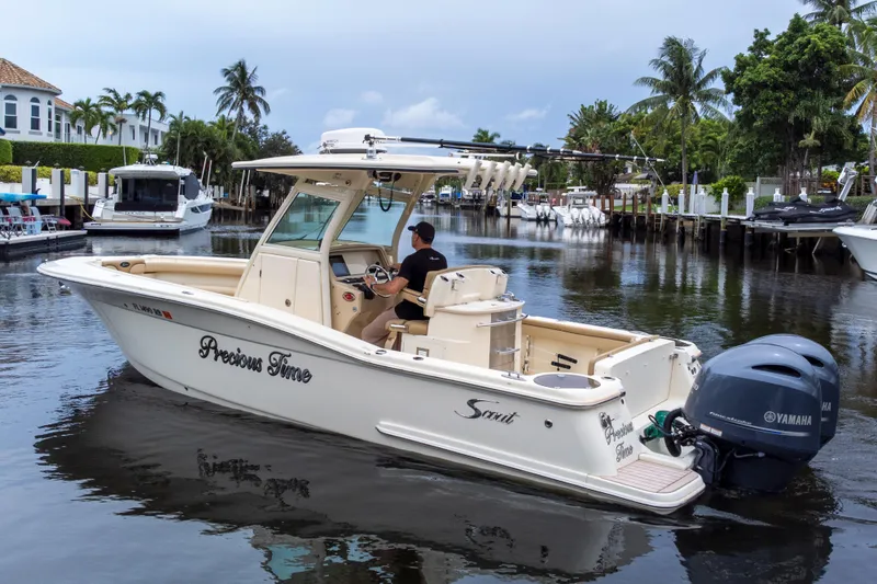 Slide: The Image of 2015 Scout 275 LXF boat cruising on a scenic waterway with palm trees. - 11