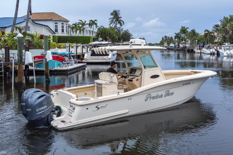 Slide: The Image of 2015 Scout 275 LXF boat cruising in a scenic canal with palm trees. - 13