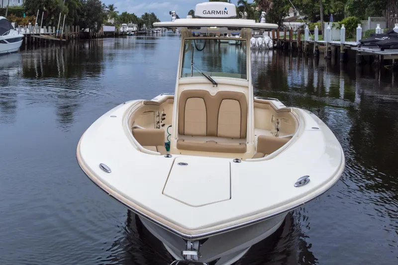Slide: The Image of 2015 Scout 275 LXF boat on a calm waterway, featuring Garmin equipment. - 15