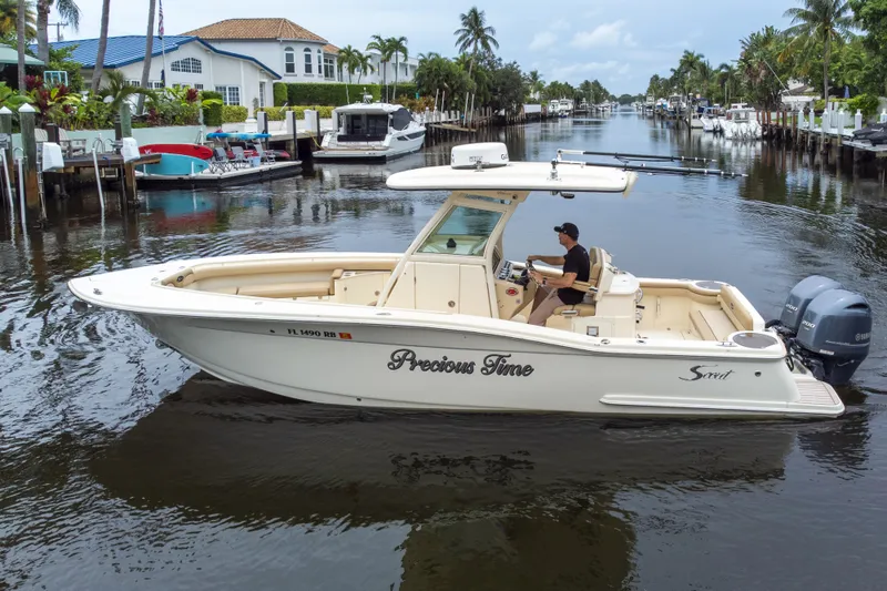 Slide: The Image of 2015 Scout 275 LXF boat cruising on a scenic canal with palm trees. - 16