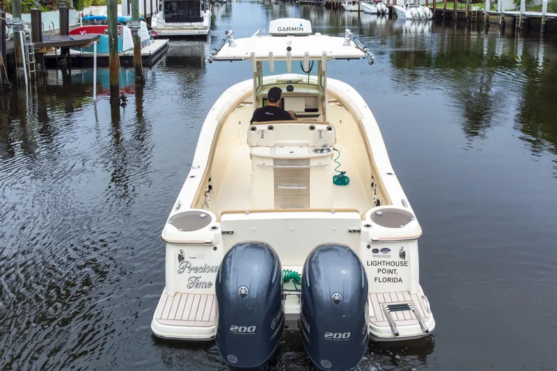 Slide: The Image of 2015 Scout 275 LXF boat with twin Yamaha engines in a marina setting. - 19