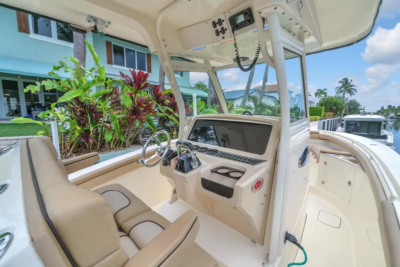 Slide: The Image of 2015 Scout 275 LXF boat interior with helm, steering wheel, and seating. - 2
