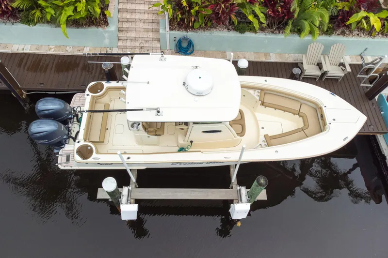 Slide: The Image of Overhead view of a 2015 Scout 275 LXF boat docked by a lush garden. - 22