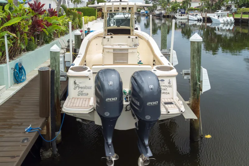 Slide: The Image of 2015 Scout 275 LXF boat docked with twin Yamaha engines in a scenic canal. - 26