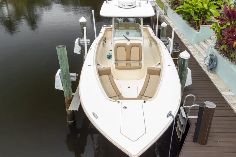 Slide: The Image of 2015 Scout 275 LXF boat docked, featuring sleek design and spacious seating. - 29