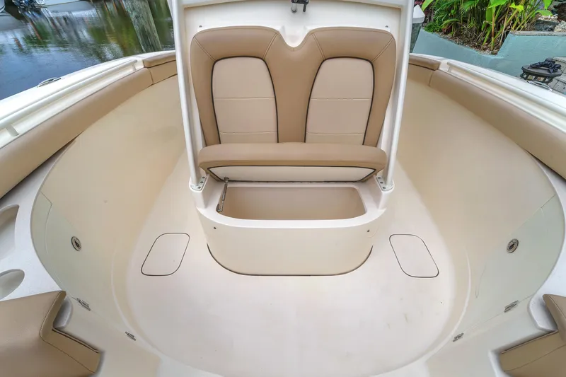 Slide: The Image of 2015 Scout 275 LXF boat interior with tan seating and storage compartments. - 34