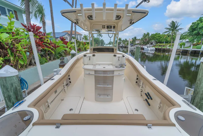 Slide: The Image of 2015 Scout 275 LXF boat docked by a scenic canal with lush greenery. - 41