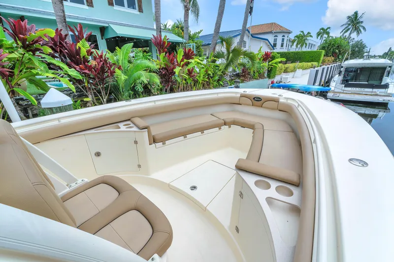 Slide: The Image of 2015 Scout 275 LXF boat interior with beige seating and lush waterfront view. - 45