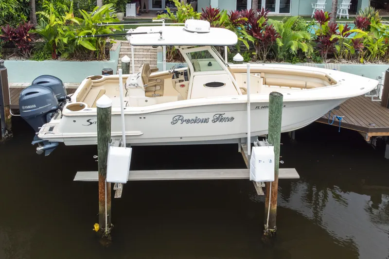 Slide: The Image of 2015 Scout 275 LXF boat docked with twin Yamaha engines, surrounded by lush greenery. - 8