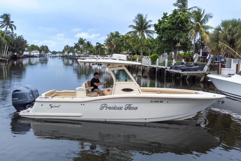 Slide: The Image of 2015 Scout 275 LXF boat cruising on a scenic waterway with palm trees. - 9