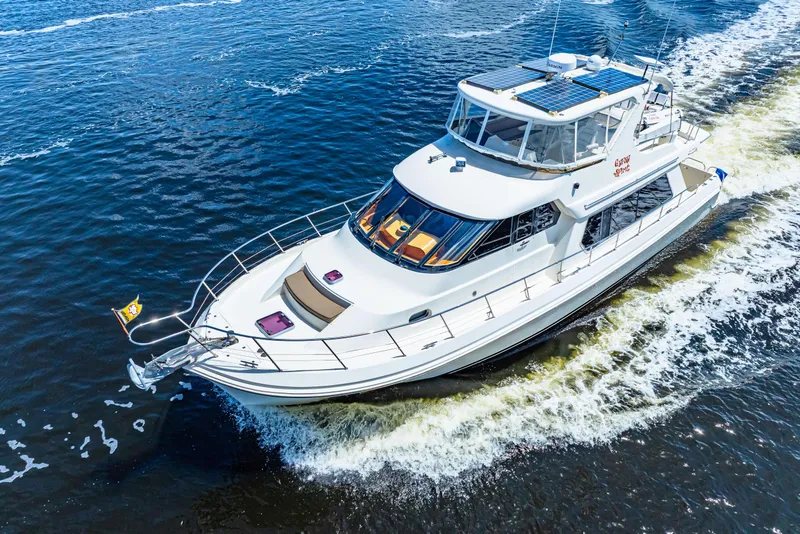 Slide: The Image of 2007 Hampton 558 Pilothouse yacht cruising on open water, aerial view. - 2