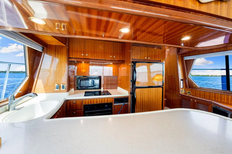 Slide: The Image of Luxurious 2007 Hampton 558 Pilothouse yacht kitchen with wood finish and ocean view. - 30