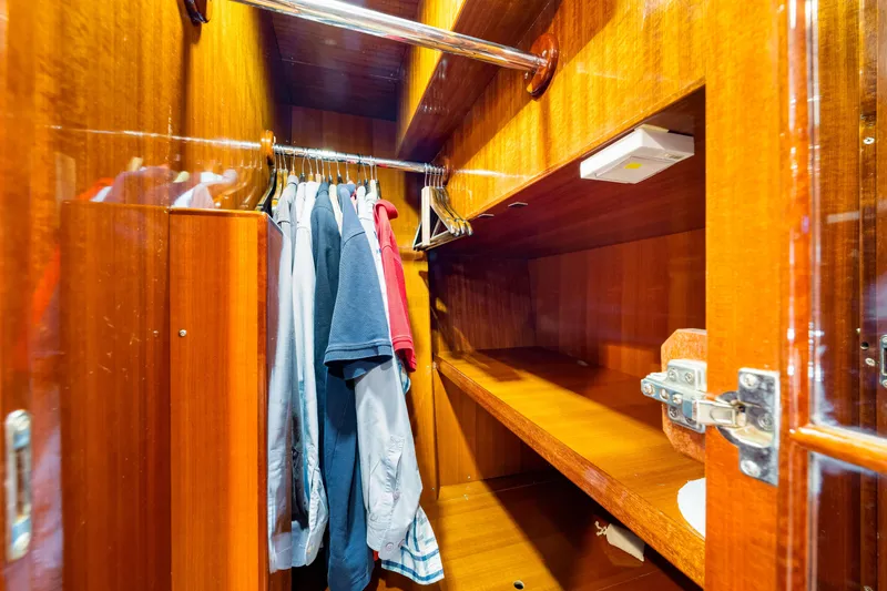 Slide: The Image of Wooden closet interior with hanging clothes in a 2007 Hampton 558 Pilothouse yacht. - 36