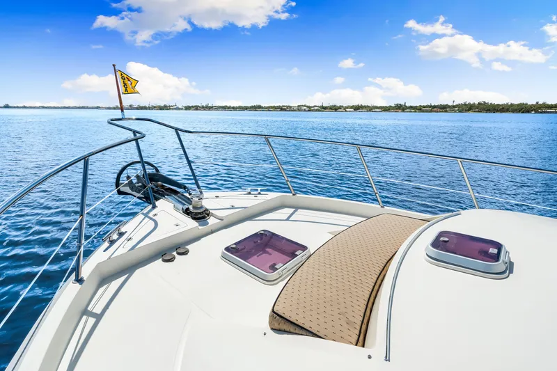 Slide: The Image of Bow view of 2007 Hampton 558 Pilothouse yacht on calm blue waters. - 60