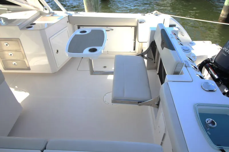 Slide: The Image of 2023 Sailfish 276 DC boat interior with seating, table, and storage compartments. - 11