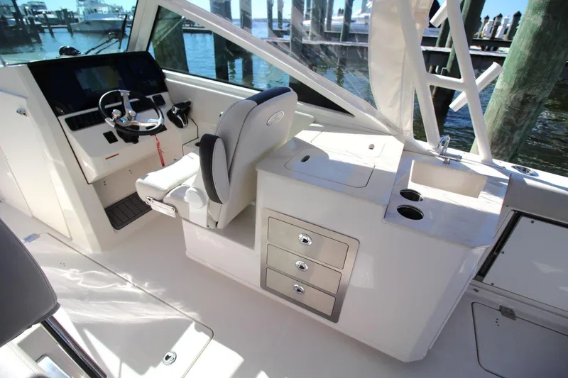 Slide: The Image of 2023 Sailfish 276 DC boat interior with helm, seating, and storage compartments. - 13