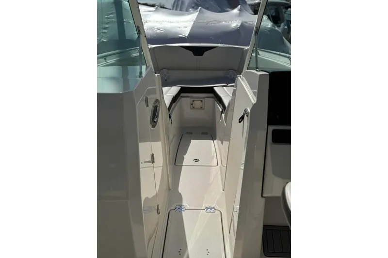 Slide: The Image of 2023 Sailfish 276 DC boat docked at a marina, surrounded by pilings. - 4