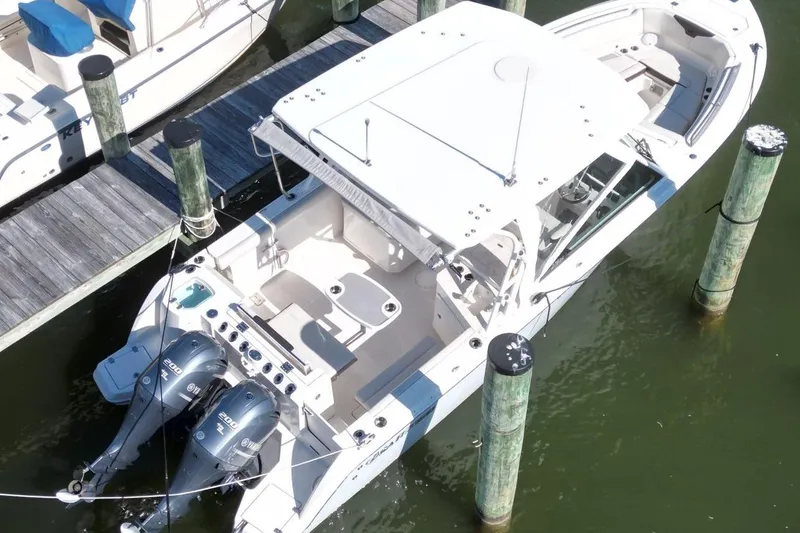 Slide: The Image of 2023 Sailfish 276 DC boat docked, featuring dual outboard engines and spacious deck layout. - 8