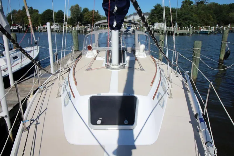 Slide: The Image of 1988 Catalina 34 sailboat docked at a marina, showcasing its deck and rigging. - 10