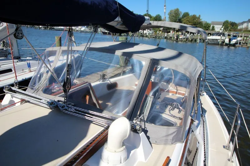 Slide: The Image of 1988 Catalina 34 sailboat with cockpit cover, docked at marina on a sunny day. - 11