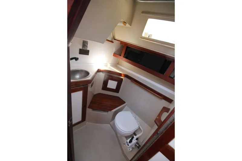 Slide: The Image of 1988 Catalina 34 yacht bathroom with sink, toilet, and wooden accents. - 23