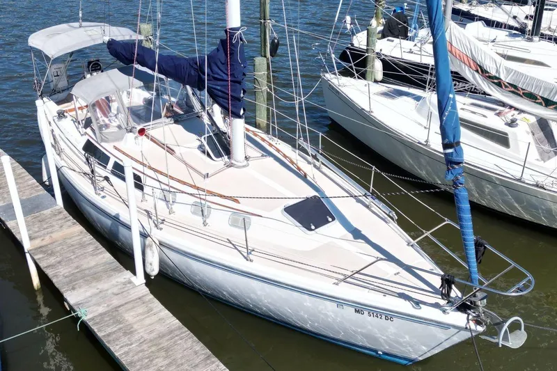 Slide: The Image of 1988 Catalina 34 sailboat docked at marina, featuring sleek design and spacious deck. - 4