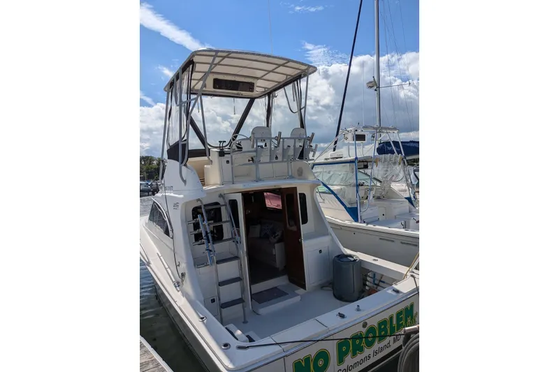 Slide: The Image of 1992 Luhrs Tournament 320 Convertible boat docked under a clear sky. - 10