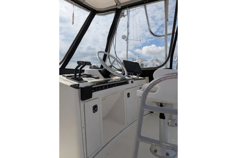 Slide: The Image of 1992 Luhrs Tournament 320 Convertible boat helm with steering wheel and controls. - 13