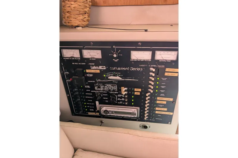 Slide: The Image of Control panel of a 1992 Luhrs Tournament 320 Convertible boat, featuring various switches and gauges. - 22