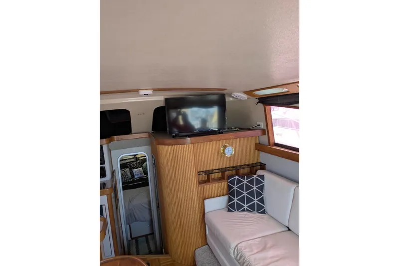 Slide: The Image of Interior of 1992 Luhrs Tournament 320 Convertible with TV, sofa, and nautical decor. - 23