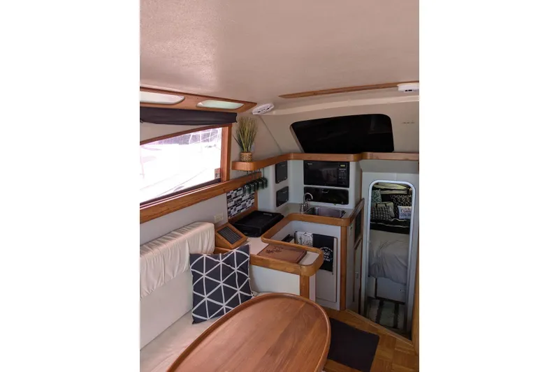 Slide: The Image of Interior of 1992 Luhrs Tournament 320 Convertible yacht with cozy seating and kitchenette. - 24