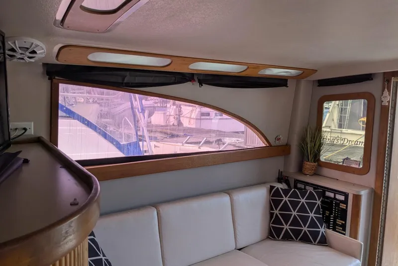Slide: The Image of Interior of 1992 Luhrs Tournament 320 Convertible with sofa, window, and decorative pillows. - 27