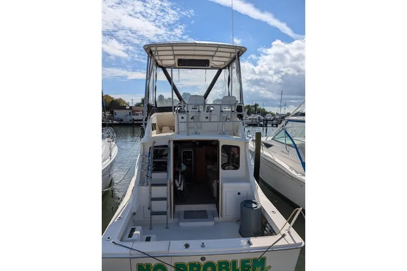 Slide: The Image of 1992 Luhrs Tournament 320 Convertible boat docked at marina under blue sky. - 4