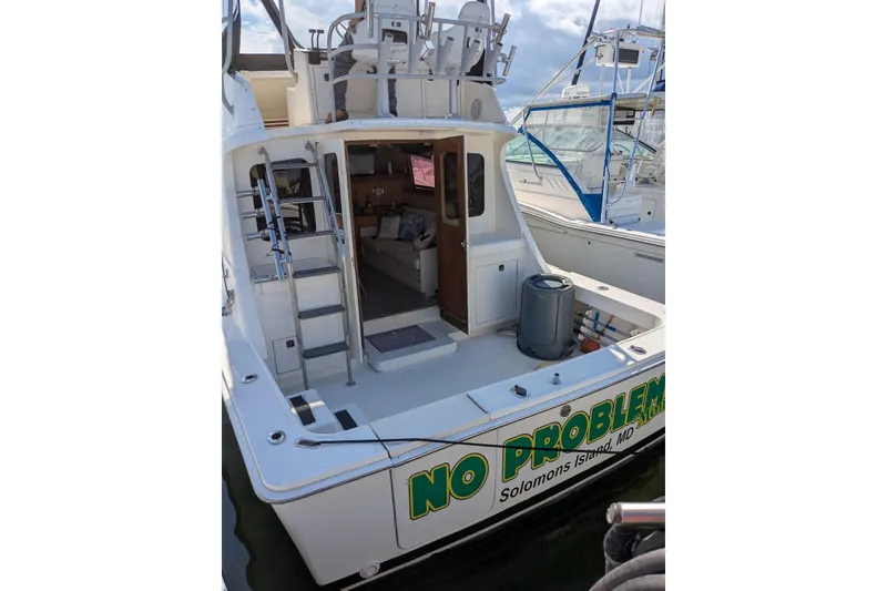 Slide: The Image of 1992 Luhrs Tournament 320 Convertible boat docked, featuring open deck and cabin entrance. - 6