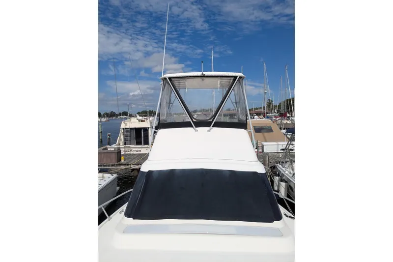 Slide: The Image of 1992 Luhrs Tournament 320 Convertible boat docked at marina under blue sky. - 7
