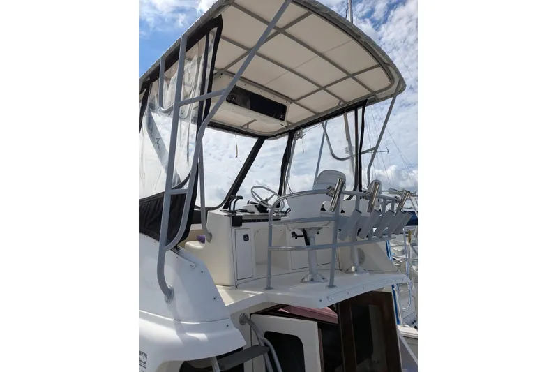 Slide: The Image of 1992 Luhrs Tournament 320 Convertible boat helm with canopy and fishing rod holders. - 9