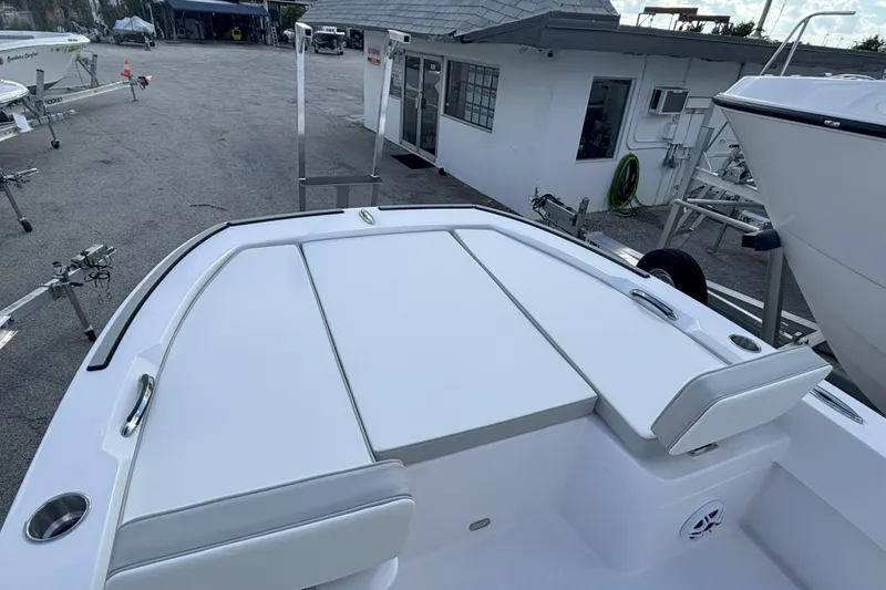 Slide: The Image of 2026 Twin Vee 22 Bay Cat boat interior with white seating and storage compartments. - 11