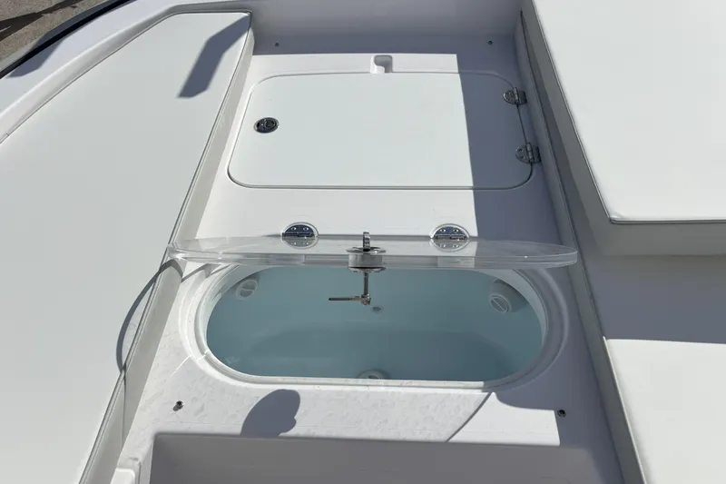 Slide: The Image of 2026 Twin Vee 22 Bay Cat boat interior with open storage compartment. - 13