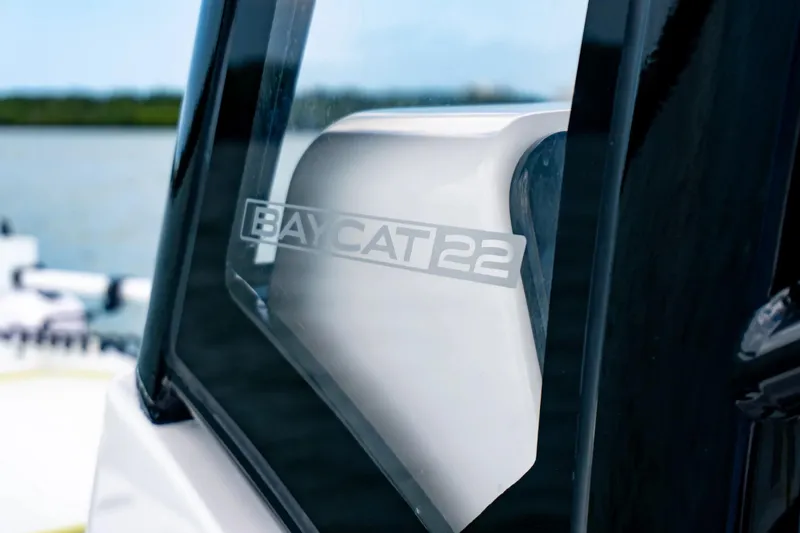 Slide: The Image of 2026 Twin Vee 22 Bay Cat boat window with model name reflection. - 16