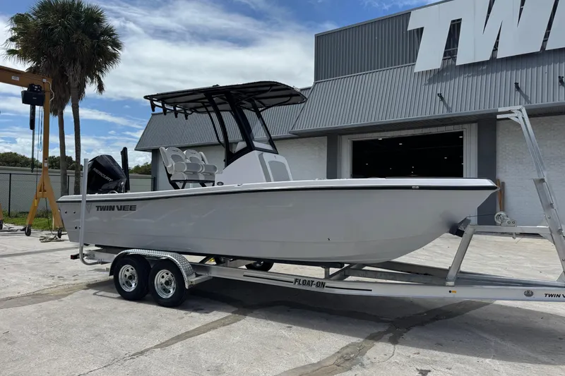 Slide: The Image of 2026 Twin Vee 22 Bay Cat boat on trailer outside showroom. - 3