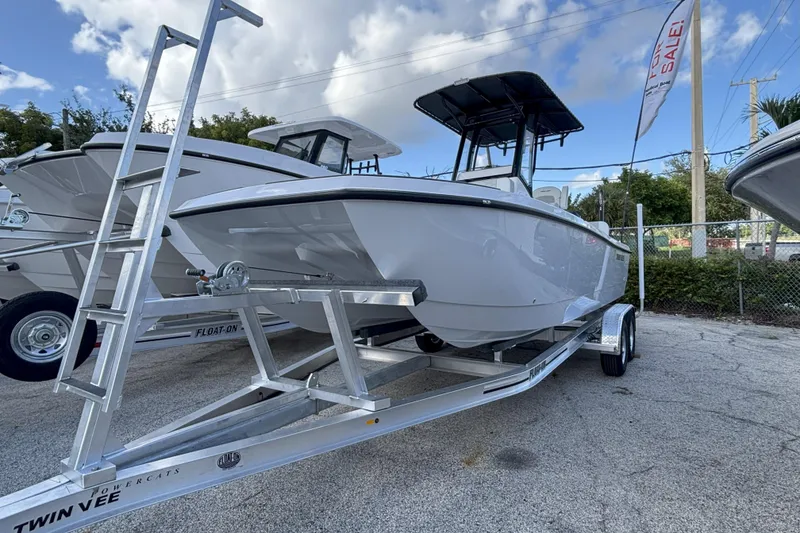Slide: The Image of 2026 Twin Vee 22 Bay Cat boat on trailer, displayed for sale under cloudy sky. - 4