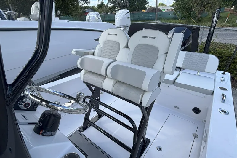 Slide: The Image of 2026 Twin Vee 22 Bay Cat boat interior with dual seats and steering wheel. - 9